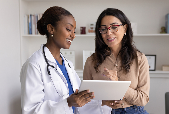 A doctor and another person looking at a tablet together