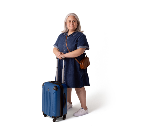 Aly, a person living with XLH, standing with a suitcase and smiling