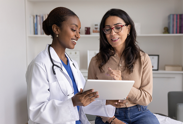 A doctor and another person looking at a tablet together