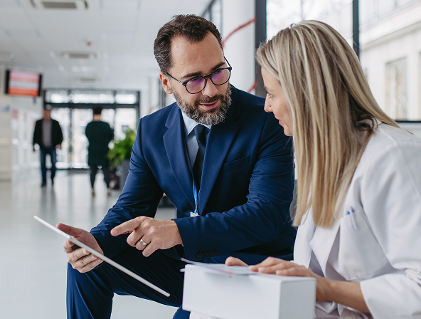 A doctor and another person looking at a tablet together